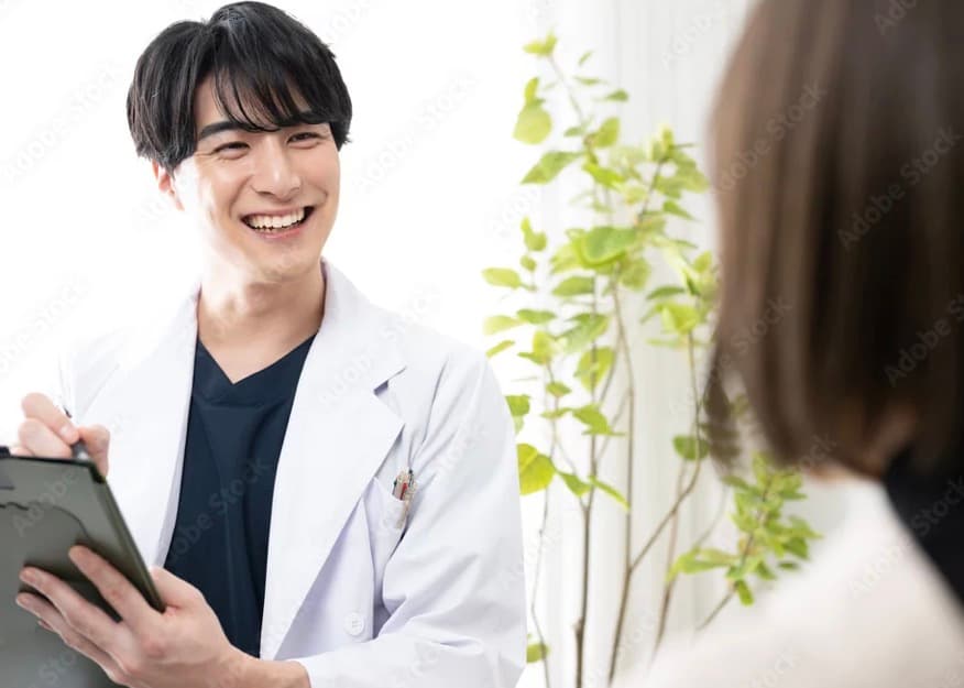 タブレットを手に笑顔でカウンセリングする歯科医師