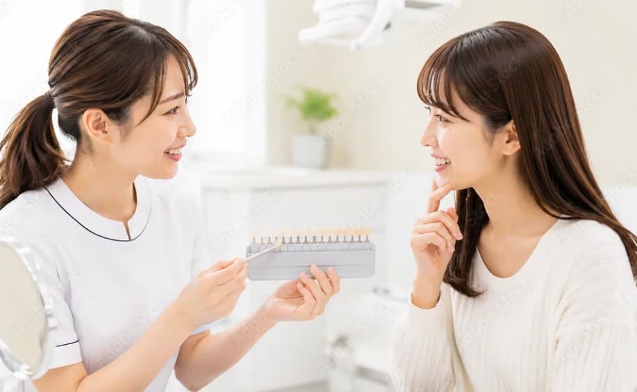 歯科衛生士がシェードガイドで歯の色を確認する様子
